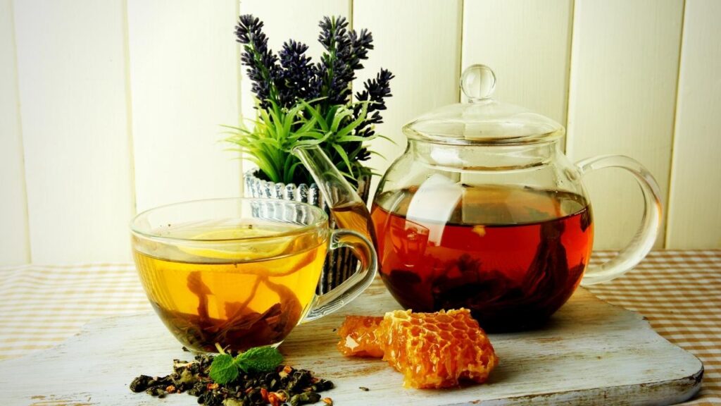 green tea in glass pot beside honeycombs