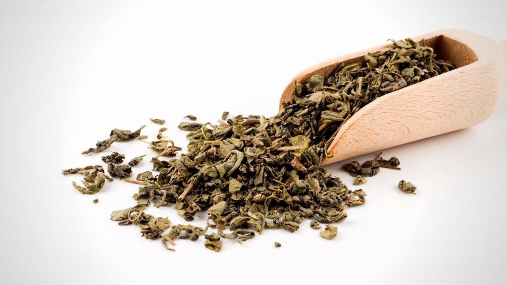 a wooden scoop of gunpowder tea leaves