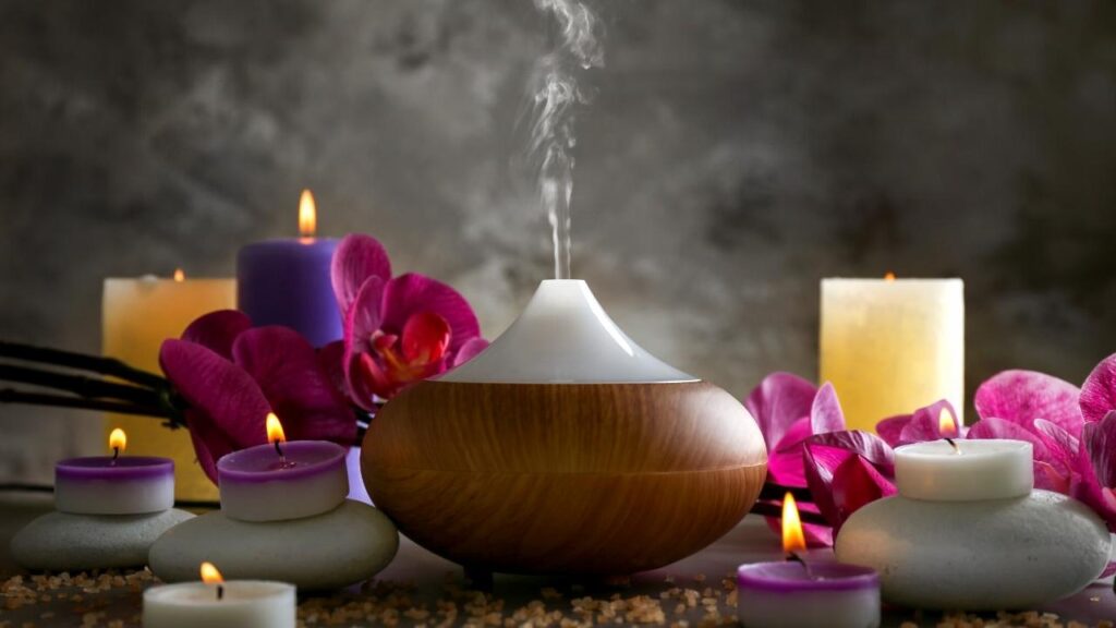 oil diffuser beside pink flowers