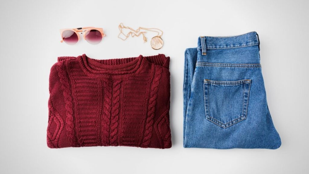 folded blue jeans and red jumper