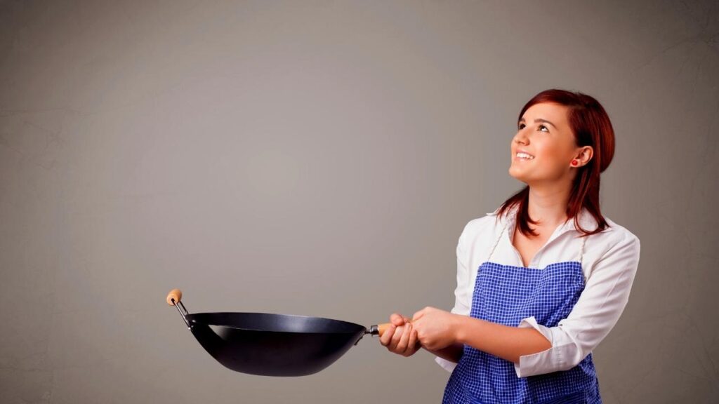 woman holding pan and looking up