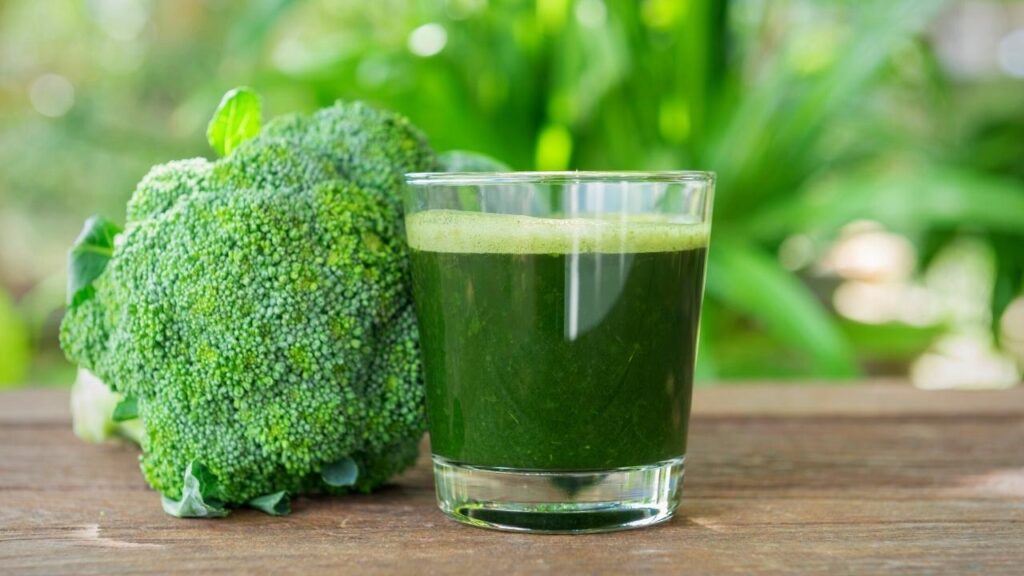 glass of green juice beside broccoli